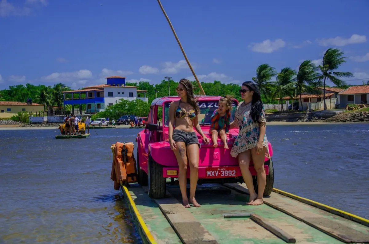 Família com buggy rosa na travessia de balsa